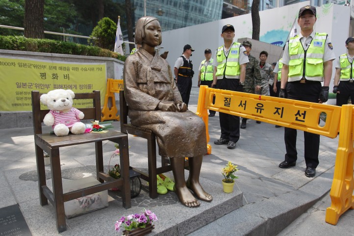 South Korean police stand guard beside a comfort woman statue in front of the Japanese embassy in Seoul in May. The Southern California city of Glendale will dedicate an identical statue on Tuesday.