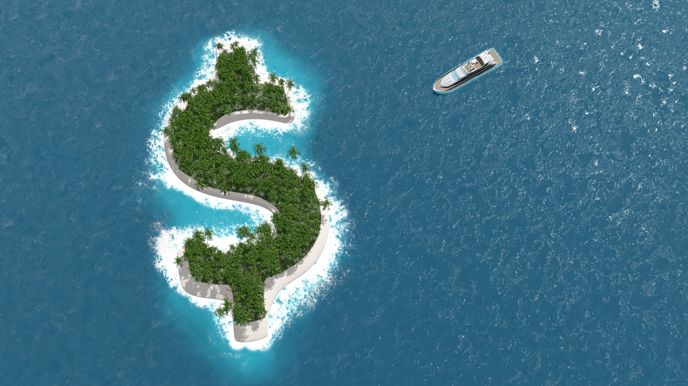 A yacht approaches a dollar-sign-shaped island in the ocean.