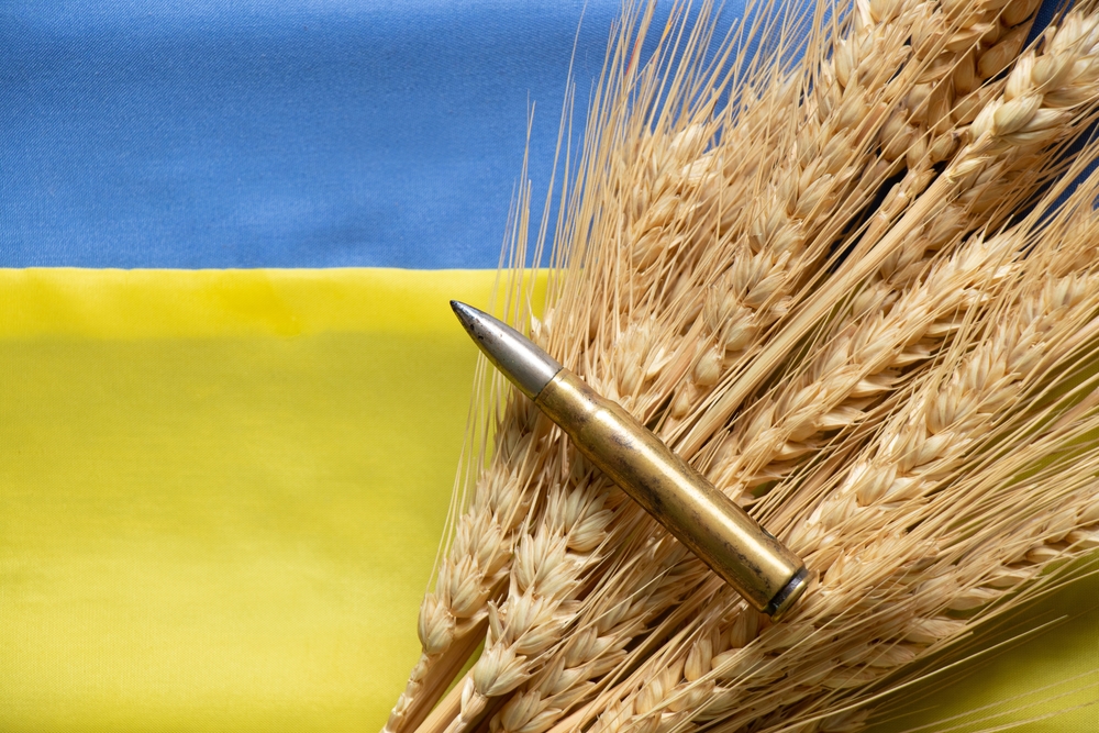 Graphic of a bullet and bunch of wheat against a Ukrainian flag backdrop