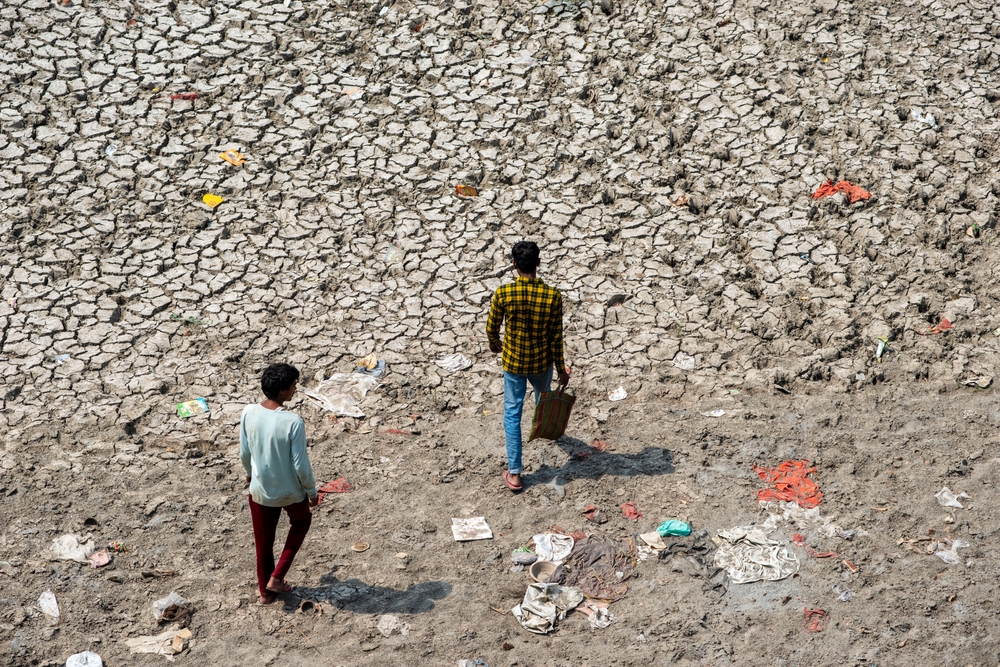 Two boys walk across a dried riverbed in New Delhi, India in May 2022. (Shutterstock)