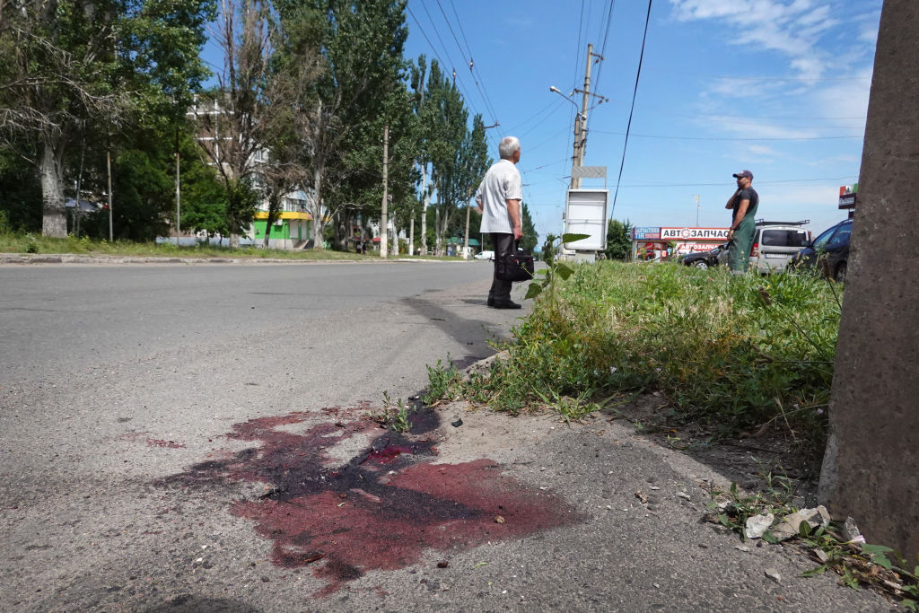 Blood runs down the road after several people were wounded in a cluster bomb attack near a grocery store on June 30, 2022 in Sloviansk, Ukraine. (Photo by Scott Olson/Getty Images)