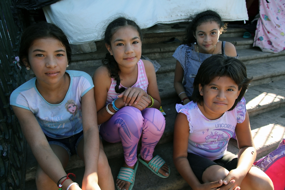 Four Central American girls at a tent for U.S. asylum seekers in Reynosa, Mexico. For years now the U.S. has forced asylum applicants to wait in Mexico, often for years and in dangerous conditions. (Shutterstock)