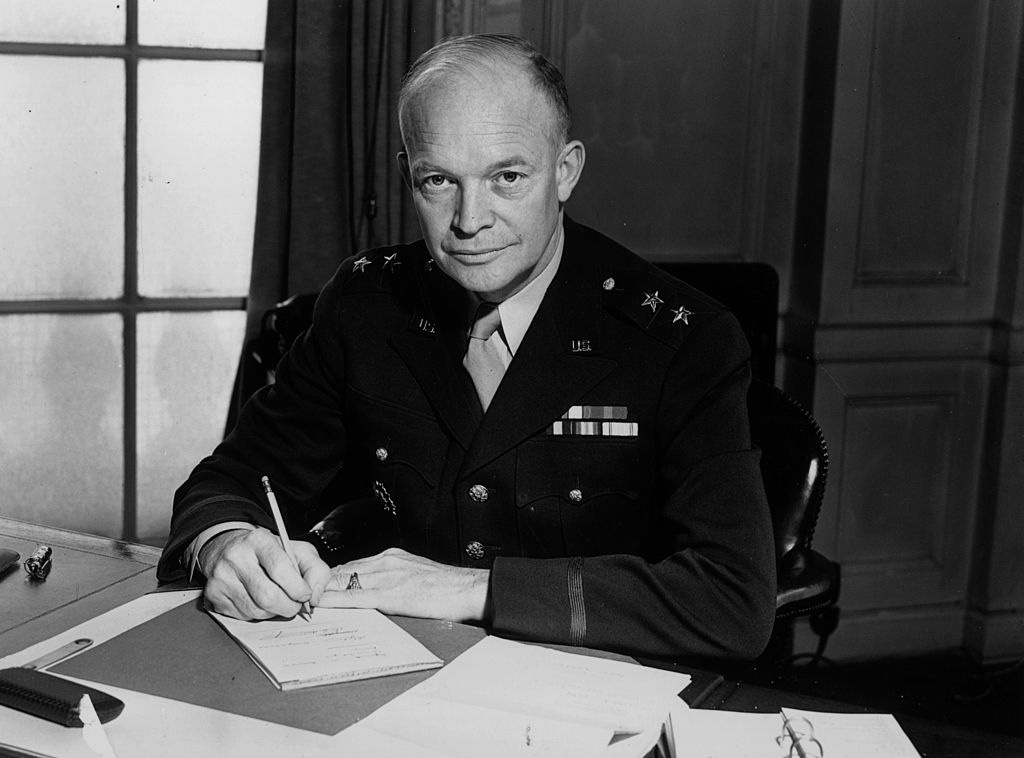 Dwight Eisenhower looks up from his desk in the Oval Office.