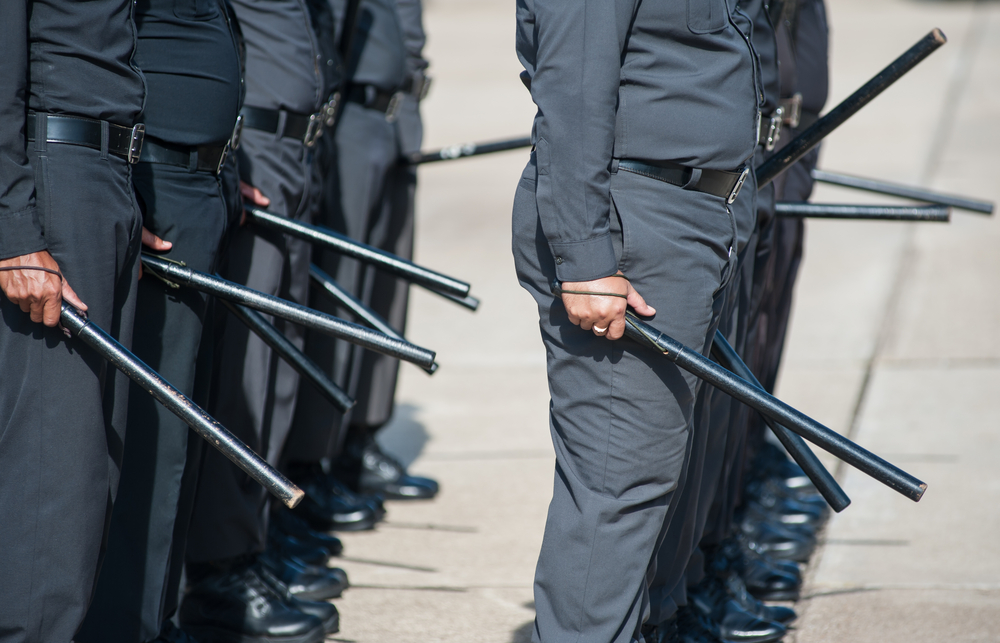 Police officers train with batons.